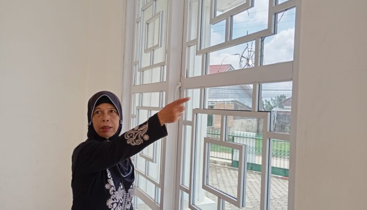 Saksi ustadzah guru mengaji tunjukkan kaca masjid yang pecah.