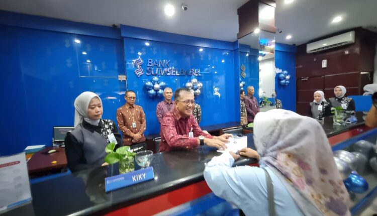 Direktur Keuangan Bank Sumsel Babel M Amrul Muslimin menjadi teller BSB Cabang Kol Atmo melayani nasabah.