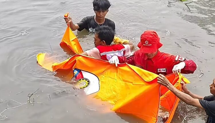 petugas bersama warga mengevakuasi jenazah.