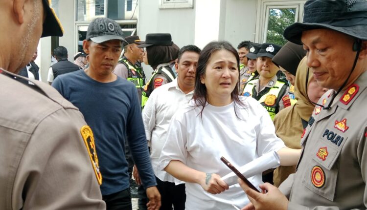 Tina Francisco mencoba menjelaskan duduk perkara kepada aparat kepolisian saat proses eksekusi lahan di kawasan Vila Sukarami berlangsung.