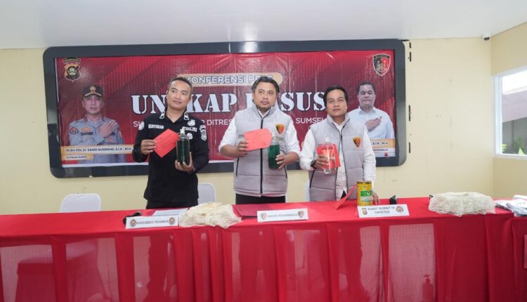 Wakil Direktur Reskrimsus Polda Sumsel AKBP Listiyono (tengah) didampingi Kasubdit IV Tipidter AKBP Ahmad Budi Martono (kanan) menunjukkan sampel BBM jenis Pertalite dan minyak olahan ilegal saat konferensi pers di Mapolda Sumsel.