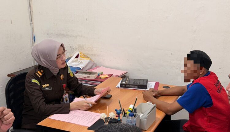 Jaksa Penuntut Umum (JPU) Kejaksaan Negeri Ogan Komering Ilir (OKI) memeriksa berkas perkara saat proses penyerahan tersangka dan barang bukti (Tahap II) kasus dugaan korupsi KUR Bank BSI.