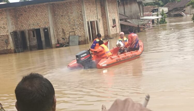 Sejumlah petugas gabungan dari BPBD Kabupaten Muratara menggunakan perahu karet untuk mengevakuasi warga yang terjebak banjir di pemukiman padat penduduk, Kabupaten Musi Rawas Utara.