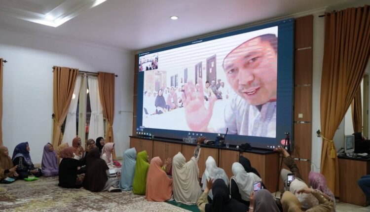 Sejumlah jajaran OPD dan keluarga jemaah haji melambaikan tangan ke arah layar saat tersambung melalui panggilan video (video call) dengan Wali Kota Pagar Alam, Ludi Oliansyah, dari Tanah Suci dalam acara yasinan dan doa bersama di Griya Rumah Dinas Wali Kota Pagar Alam, Sumatra Selatan.
