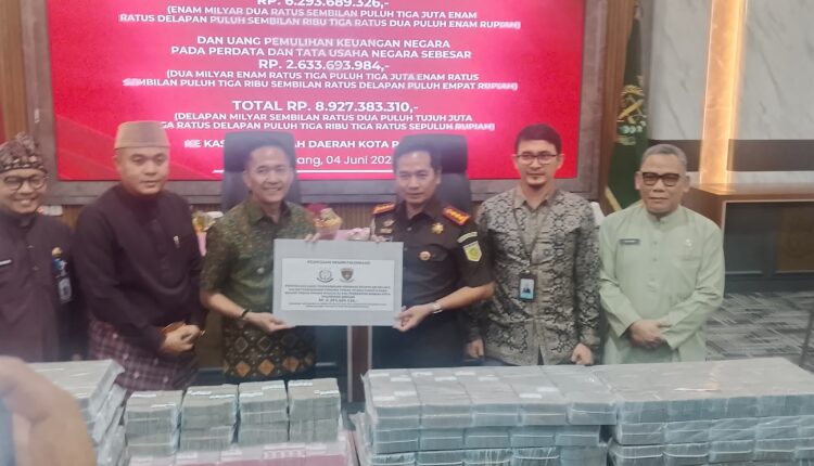 Kepala Kejaksaan Negeri Palembang, M Ali Akbar (tengah kanan), bersama Wali Kota Palembang, Ratu Dewa (tengah kiri), menunjukkan papan berita acara penyerahan uang pemulihan keuangan negara di Kantor Wali Kota Palembang, Sumatra Selatan.