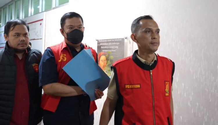 Wakil Bupati PALI, Iwan Tuaji (tengah), mengenakan rompi tahanan dengan tangan terborgol saat digiring oleh Tim Penyidik Tindak Pidana Khusus (Pidsus) menuju ruang pemeriksaan di Kantor Kejaksaan Tinggi Sumatera Selatan, Palembang.
