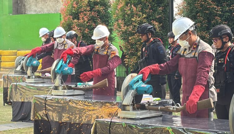 Pemotongan senjata api rakitan laras panjang menggunakan mesin gerinda saat pemusnahan barang bukti di Lapangan Tembak Brimob Polda Sumsel, Palembang.