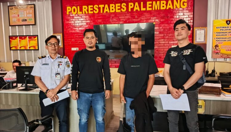Tersangka pencurian berinisial MR (53, tengah berwajah disamarkan) dikawal petugas keamanan PT KAI dan anggota kepolisian saat diserahkan ke SPKT Polrestabes Palembang.