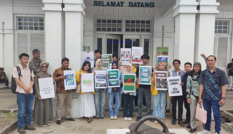 Sejumlah mahasiswa dari berbagai universitas di Palembang membentangkan poster tuntutan saat menggelar aksi solidaritas di depan Pengadilan Negeri Palembang, Sumatera Selatan.