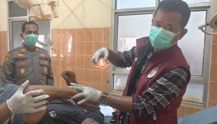 Petugas medis didampingi personel kepolisian memeriksa kondisi jenazah seorang sopir truk berinisial PAK (51) di Puskesmas Betung, Kabupaten Banyuasin, Sumatra Selatan.