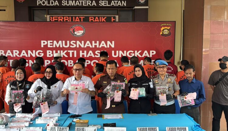 Aparat kepolisian bersama perwakilan kejaksaan menunjukkan barang bukti narkotika jenis sabu-sabu dan ekstasi sebelum dimusnahkan di halaman Mapolda Sumatera Selatan, Palembang.