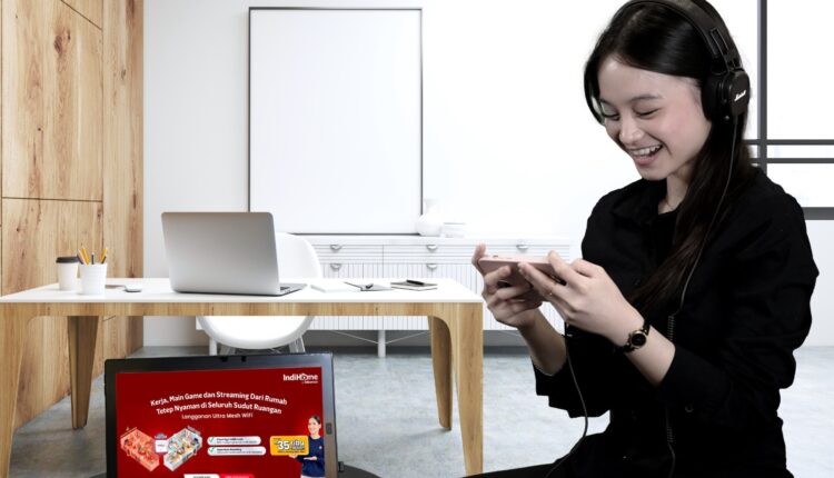 Seorang pelanggan menikmati layanan hiburan digital dan streaming game dengan koneksi internet yang stabil di rumahnya.