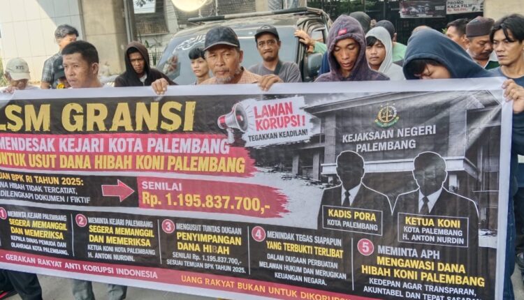 Sejumlah massa dari LSM GRANSI dan Forum LSM Bersatu membentangkan spanduk tuntutan saat menggelar aksi damai di depan Kantor Kejaksaan Negeri (Kejari) Palembang.