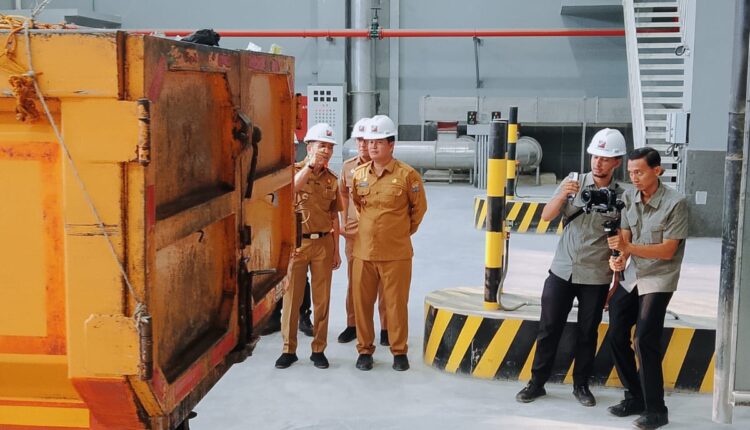 Wali Kota Palembang Ratu Dewa didampingi Kepala Dinas Lingkungan Hidup Kota Palembang Akhmad Mustain memperhatikan proses penurunan muatan truk armada pengangkut sampah saat meninjau langsung operasional perdana fasilitas Pengolahan Sampah Menjadi Energi Listrik (PSEL) di Kecamatan Kertapati, Kota Palembang.