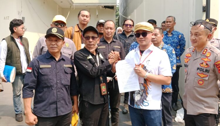 Kuasa hukum pemenang lelang, Redho Junaidi, menunjukkan dokumen grosse risalah lelang bersama petugas kepolisian dan pihak terkait saat pelaksanaan eksekusi tanah dan bangunan di Perumahan Garuda Taman Kenten Blok A Nomor 17, Kelurahan 8 Ilir, Palembang.