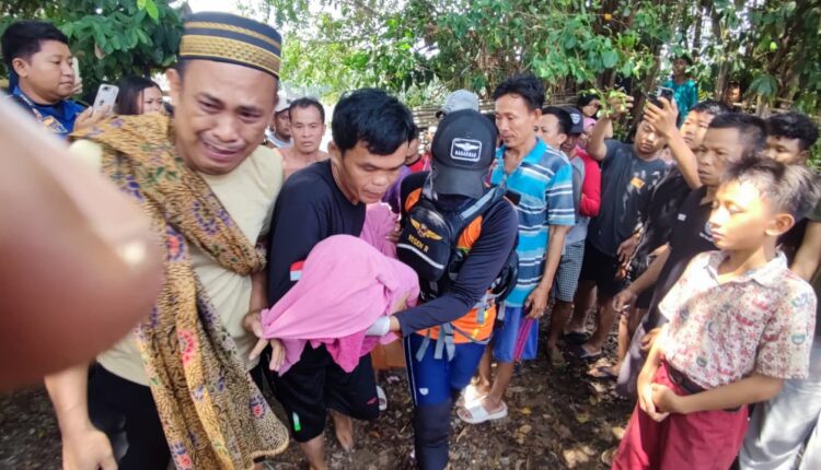 Tim SAR Gabungan dibantu warga mengevakuasi jenazah Rapi Pratama (9) yang terbungkus kain merah muda menuju rumah duka di Desa Riang Bandung, Kecamatan Madang Suku II, Kabupaten OKU Timur.