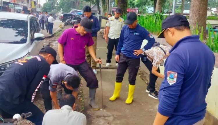 Organisasi Perangkat Daerah (OPD) Kota Pagar Alam bergotong royong membersihkan material sampah dan lumpur yang menyumbat saluran drainase di kawasan Terminal Nendagung.