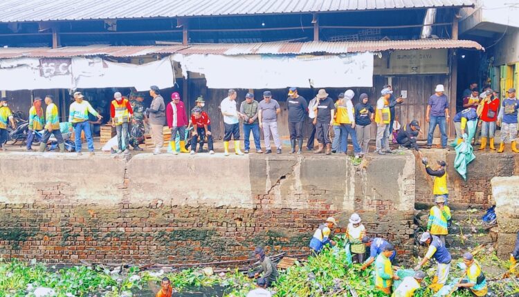 Personel TNI dari Kodim 0418/Palembang, petugas Pemkot Palembang, dan warga bergotong royong membersihkan tumpukan sampah serta tanaman enceng gondok di aliran Sungai Sekanak, Kecamatan Ilir Barat II, Kota Palembang.