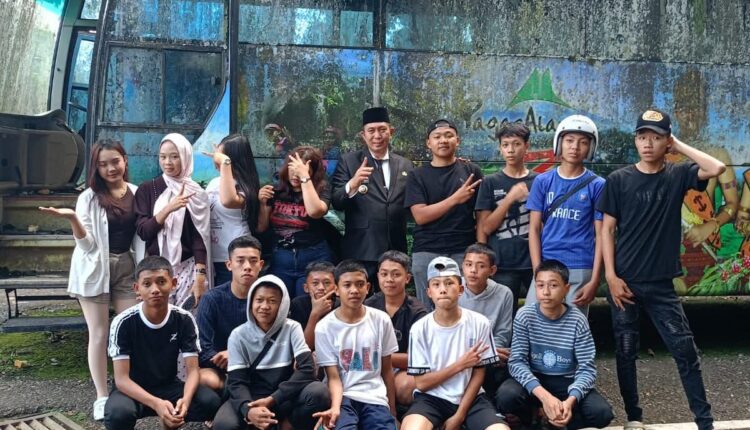 Berlatar belakang bus dinas Pemkot Pagar Alam yang sudah tidak terpakai, sekelompok siswa sekolah berkumpul untuk mengabadikan momen kebersamaan mereka.
