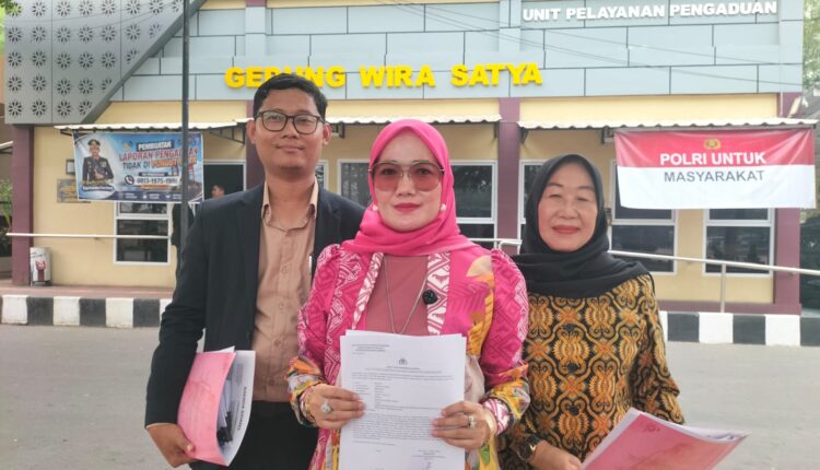 Korban berinisial ML (tengah) didampingi kuasa hukumnya, Conie Pania Putri, dan Selamet Widadi, menunjukkan surat laporan polisi di depan Gedung Wira Satya Polrestabes Palembang, Sumatera Selatan.