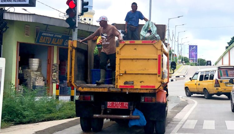 Sejumlah pekerja yang sedang mengangkut sampah. (Foto: Tia)