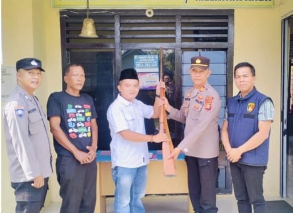 Kades Sadar Karya saat menyerahkan senpi rakitan jenis kecepek tanpa amunisi.