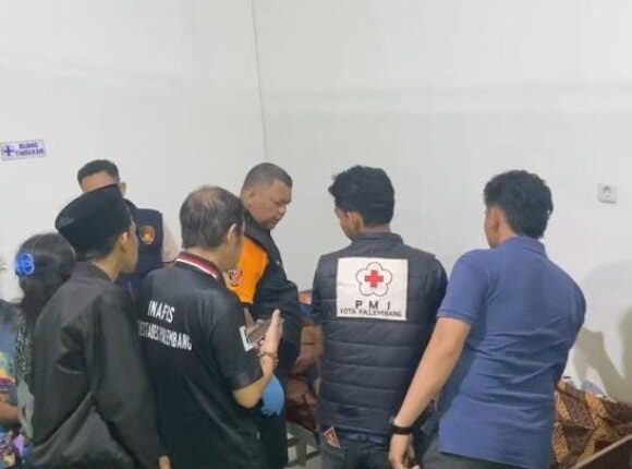 Petugas saat mengidentifikasi jasad korban di RS Bhayangkara Palembang.