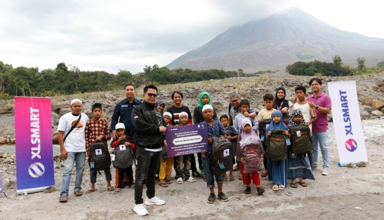 Territory Sales XLSMART area Medan, Nazar Ruddin (depan sebelah kiri) saat menyerahkan santunan paket sekolah kepada anak-anak di kaki Gunung Sinabung, Kabupaten Karo, Provinsi Sumatera Utara.