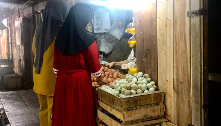 Pedagang telur saat sedang melayani pembeli di Pasar Lemabang, Kota Palembang. (Foto: Tia)
