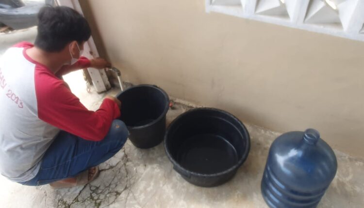 Salah satu warga Kelurahan Bukit Baru, Ganda menunjukkan air yang tidak mengalir dari kran.