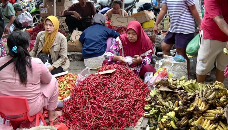Pedagang tengah melayani seorang konsumen yang sedang membeli cabai merah keriting di Pasar KM 5 Palembang. (Foto: Tia)
