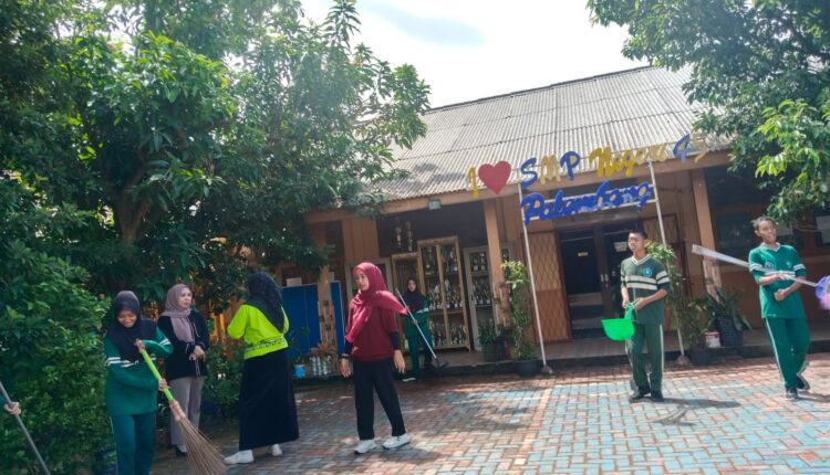 Guru dan siswa melakukan bersih-bersih di lingkungan sekolah.
