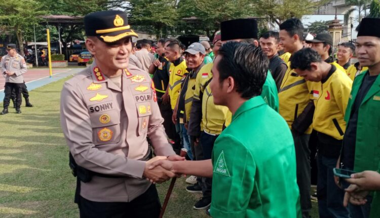 Kapolrestabes Palembang, Kombes Pol Sonny Mahar Budi Adityawan, berjabat tangan erat dengan kader GP Ansor saat memimpin Apel Sabuk Kamtibmas di Mapolrestabes Palembang.