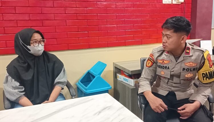 Terduga pelaku penipuan berinisial FY (kiri) saat memberikan keterangan kepada Pamapta Ipda Hendra Yuswoyo (kanan) di ruang SPKT Polrestabes Palembang.