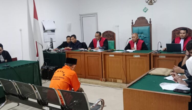 Terdakwa Sutarnedi alias Haji Sutar (tengah/baju oranye) mendengarkan pembacaan putusan dalam sidang perkara TPPU hasil narkotika di Pengadilan Negeri Palembang.