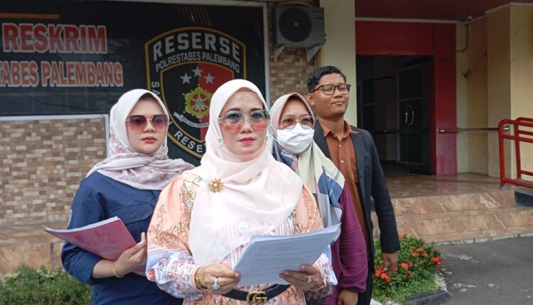 Didampingi tim kuasa hukum dari LBH Bima Sakti, Sella Mustika menunjukkan berkas laporan di depan gedung Reskrim Polrestabes Palembang.