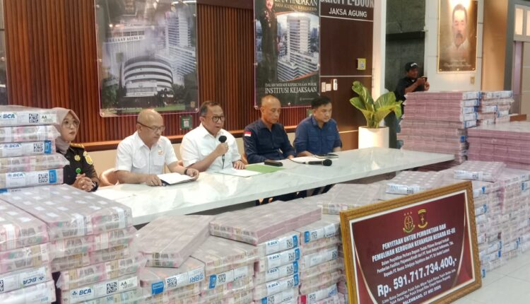 Kepala Kejaksaan Tinggi Sumatera Selatan, Ketut Sumedana, memberikan keterangan pers di depan tumpukan uang sitaan senilai Rp 591 milyar di Kantor Kejati Sumsel.