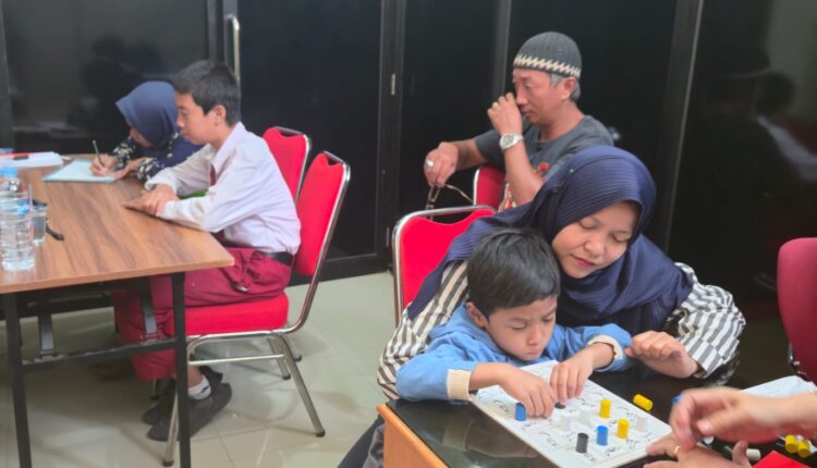 Seorang anak berkebutuhan khusus (ABK) didampingi ibunya mengikuti tes asesmen awal menggunakan alat peraga edukatif bersama tim ahli psikolog di Ruang Rapat Dinas Pendidikan Kota Palembang, Sumatra Selatan.