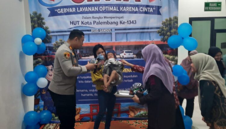 Kapolsek Gandus berpakaian dinas cokelat dan para tenaga medis berbaju ungu memberikan bingkisan/hadiah kepada anak yang baru selesai dikhitan agar mereka tetap tenang dan gembira.