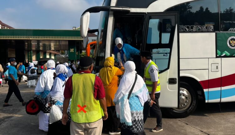 Sejumlah jemaah haji kloter pertama turun dari bus setibanya di Asrama Haji Palembang, Sumatera Selatan.