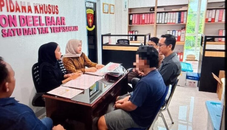 Tersangka berinisial AAM (tengah, memakai kaus biru dengan wajah disamarkan) didampingi penyidik menjalani proses pemeriksaan administrasi oleh Jaksa Penuntut Umum (JPU) di ruang Seksi Tindak Pidana Khusus Kejaksaan Negeri Ogan Komering Ilir (Kejari OKI), Sumatra Selatan.
