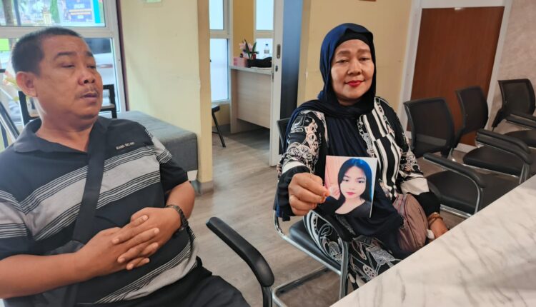 Pasangan suami istri M Fikri (51) dan Etty Sumiaty (45) menunjukkan foto anak perempuan mereka, Fera Julianty (16), saat membuat laporan orang hilang di Sentra Pelayanan Kepolisian Terpadu (SPKT) Polrestabes Palembang, Sumatra Selatan.