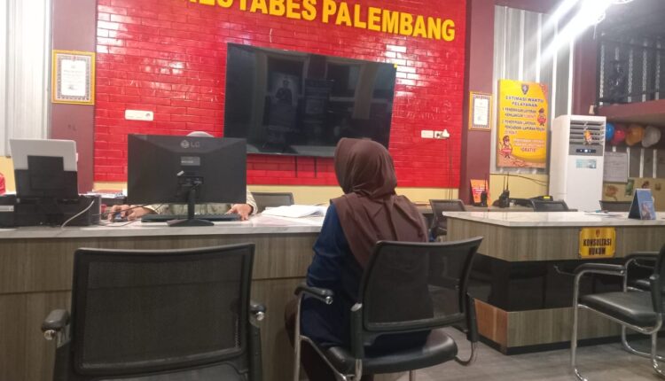 Ema Huzairoh (44), istri dari anggota polisi berinisial JE yang menjadi korban pembegalan, saat membuat laporan di Sentra Pelayanan Kepolisian Terpadu (SPKT) Polrestabes Palembang.