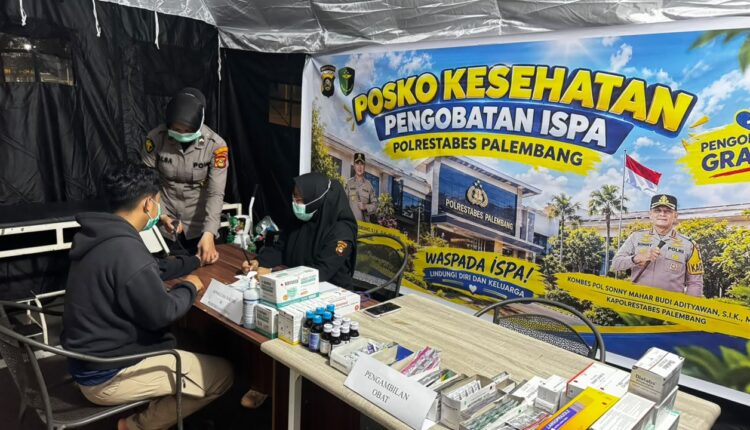 Petugas medis bersiap melayani masyarakat di Posko Kesehatan Pengobatan ISPA gratis Polrestabes Palembang, Sumatera Selatan.