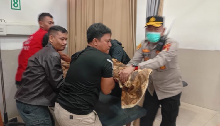 Petugas kepolisian saat membantu proses pemindahan korban pengeroyokan maut yang terjadi di kawasan Jalan KH Ahmad Dahlan, Kecamatan Bukit Kecil, Palembang.