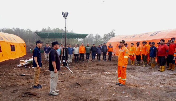 Komandan regu memberikan laporan kepada jajaran kepala daerah saat pelaksanaan apel pagi personel gabungan TNI, Polri, BPBD, dan relawan mahasiswa di Posko Induk Karhutla Desa Jungkal, Kecamatan Pampangan, Kabupaten Ogan Komering Ilir (OKI), Sumatra Selatan.