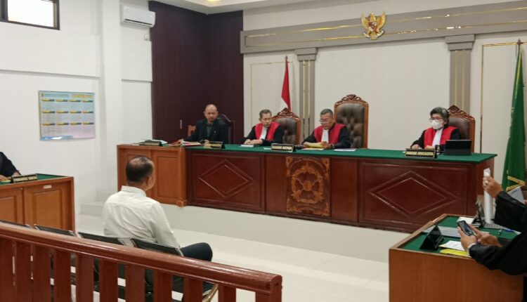 Terdakwa Indrullah Mukhlis (duduk menghadap hakim, kemeja putih) mendengarkan pembacaan surat dakwaan oleh Jaksa Penuntut Umum (JPU) dalam sidang perkara dugaan korupsi pungutan liar (pungli) penerbitan Surat Persetujuan Berlayar (SPB) UPP Kelas III Sungai Lumpur di Pengadilan Tindak Pidana Korupsi (Tipikor) Palembang, Sumatera Selatan.