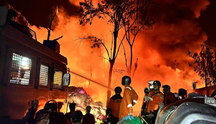 Petugas pemadam kebakaran dari tim gabungan bersama warga berusaha memadamkan kobaran api yang melalap sebuah gudang barang bekas di kawasan Simpang Kerte Diwe, Jalan Haji Piagam, Lintas Pagar Alam-Lahat, Kelurahan Karang Dalo, Kecamatan Dempo Tengah, Kota Pagar Alam.