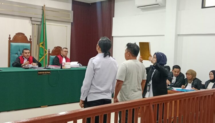 Petugas pengadilan mengangkat kitab suci saat prosesi pengambilan sumpah terhadap dua anggota polisi Polda Sumsel, M Rozi dan Eko Jaya, sebagai saksi dalam sidang kasus dugaan manipulasi data elektronik aktivasi sinyal iPhone internasional (inter) di Pengadilan Negeri (PN) Palembang.