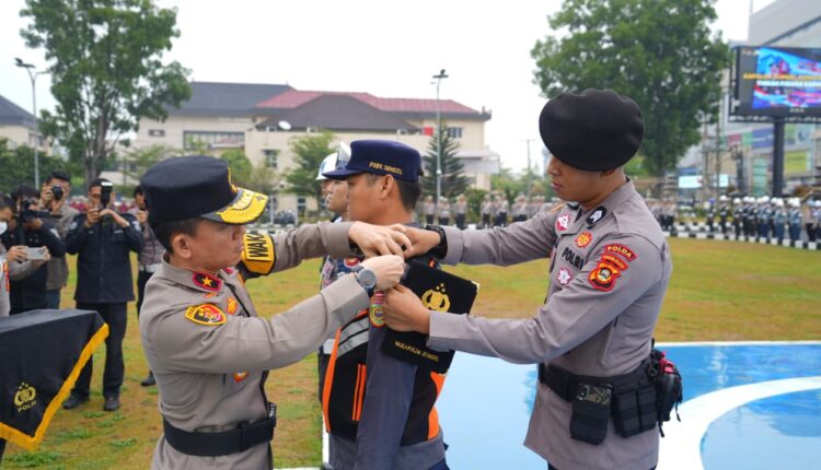 Wakapolda Sumsel Brigjen Pol Irwansyah menyematkan pita tanda dimulainya operasi kepada perwakilan personel gabungan saat memimpin Apel Gelar Pasukan Operasi Patuh Musi 2026 di Lapangan Mapolda Sumatera Selatan, Palembang.
